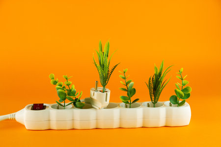 Plants in the white plastic socket on orange background. Copy space.の写真素材