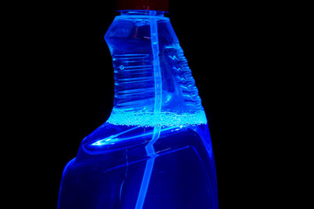 A bottle of water on a black background with blue light inside.の写真素材