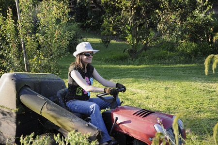 Woman cutting grass, working in the garden, beautiful green color.