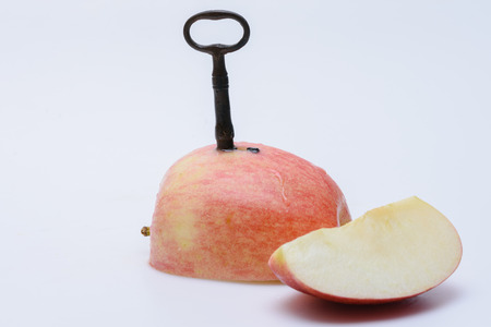 Fresh apple with key stuck into backの写真素材