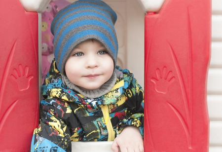 Happy boy peeking out of a toy house , close-upの写真素材
