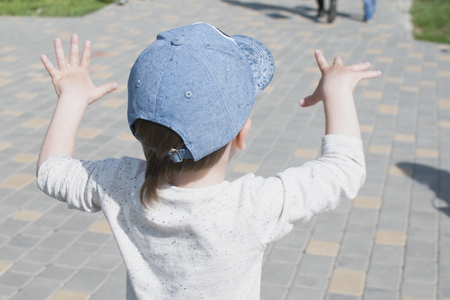 A little boy in the city plays near the fountain with waterの写真素材