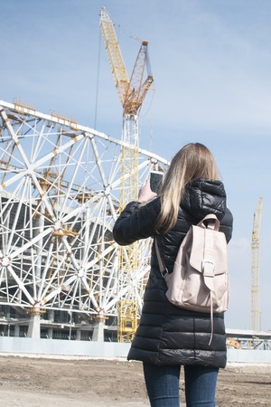 Girl is photographing on the phone building a phoneの写真素材