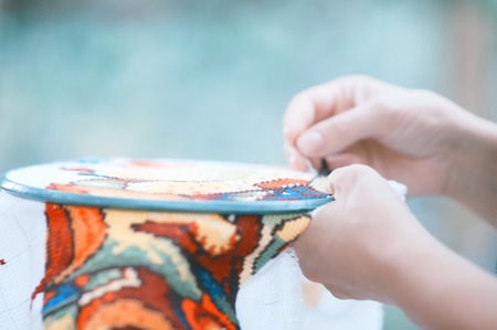 Hands of a woman, cross-stitch, close-upの写真素材