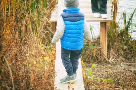 Child at the river, autumn, fishing rodの写真素材