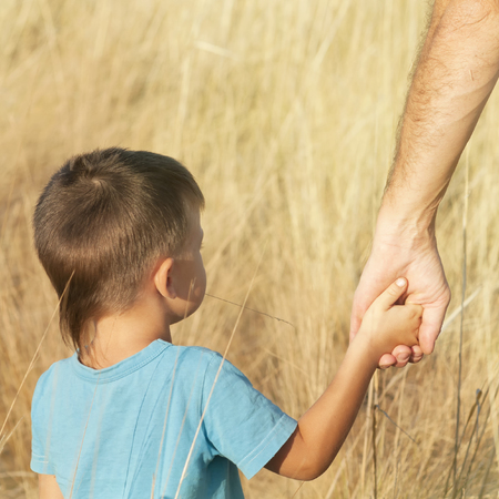 Father and son hold hands, hand in hand, effect of instagramの写真素材