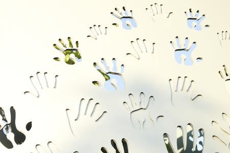 Handprints, adults and childrens palms make a natural pattern on a white wooden background. The concept of friendship and artの写真素材