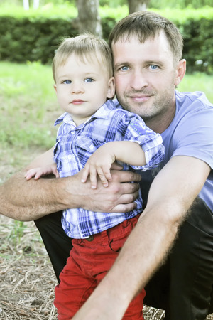 Father and son together, with the same blue eyes, look at the cameraの写真素材