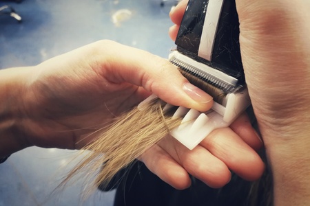 Haircut in the beauty salon, polishing hair with a special typewriter with a nozzle, healthy hair, close-up,の写真素材