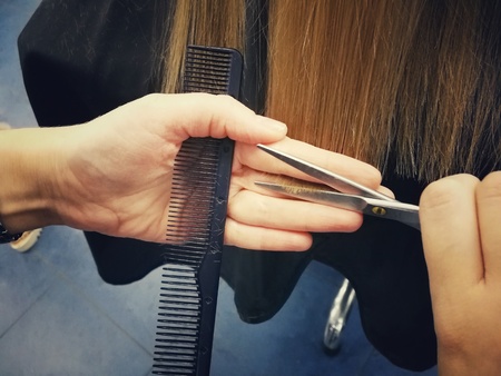 Haircut in the beauty salon, polishing hair with a special typewriter with a nozzle, healthy hair, close-up,の写真素材