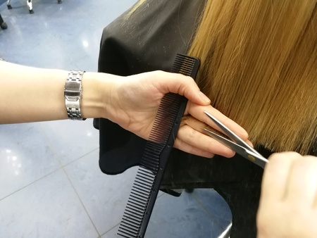 Haircut in the beauty salon, polishing hair with a special typewriter with a nozzle, healthy hair, close-up,の写真素材