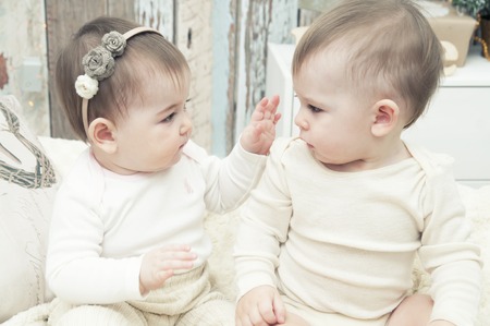 Two small children, a boy and a girl in natural cloth diapers, natural swaddling, eco-friendly cotton fabricsの写真素材