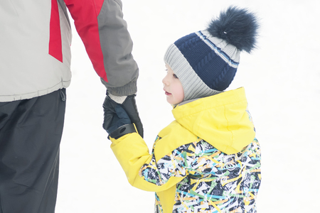 Father holds the boys hand in winter clothes, winter, family, hand in hand, lifestyleの写真素材