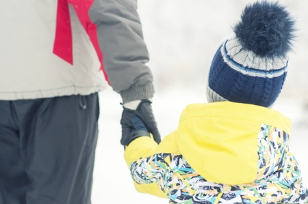 Father holds the boys hand in winter clothes, winter, family, hand in hand, lifestyleの写真素材