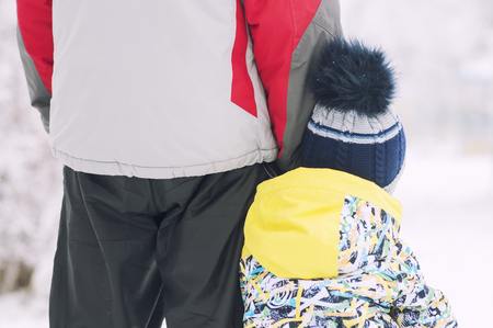 Father holds the boys hand in winter clothes, winter, family, hand in hand, lifestyleの写真素材