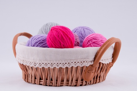 A ball of yarn for knitting in the basket on a grey background