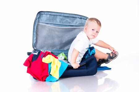 Small tourist collects things in a suitcase for travelの写真素材