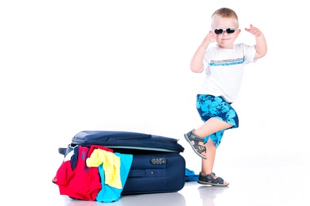 Small tourist collects things in a suitcase for travelの写真素材