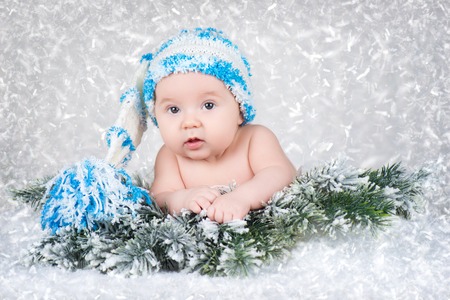 Newborn baby in a knitted cap. Snow background.の写真素材