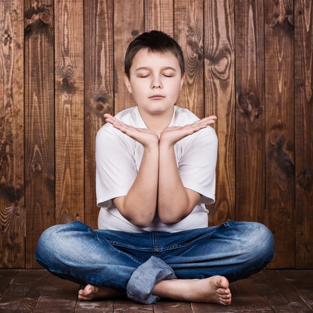 Boy in a suit in lotus position.の写真素材