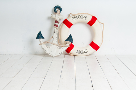 Anchor and life buoy on a white wooden floorの写真素材