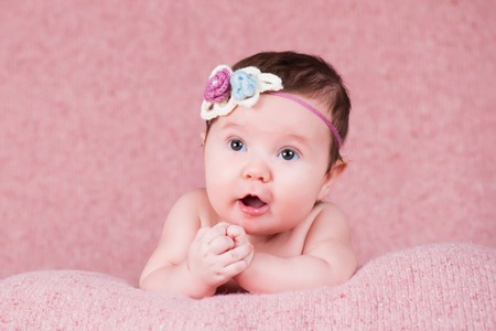 Newborn girl portrait with knitted bandage in the form of a flower.の写真素材