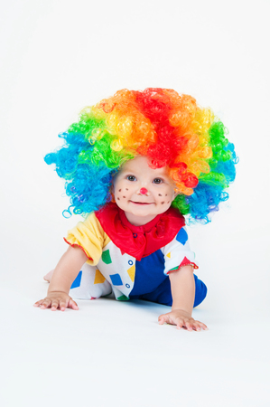 Child clown with a red nose multicolored wig in with ballsの写真素材