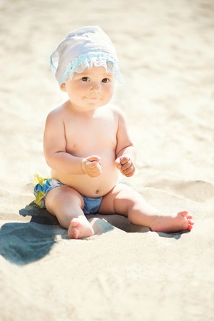 Adorable toddler girl playing on white sand beachの写真素材