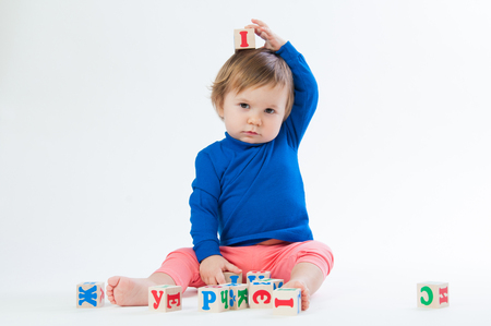 Little child playing with dices isolated on white backgroundの写真素材
