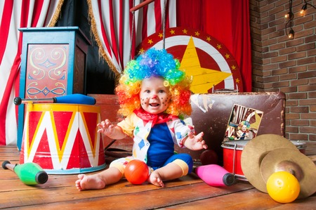 Little baby clown with red nose multi-colored wig in with ballsの写真素材
