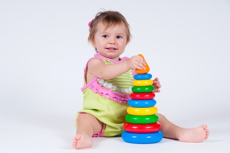 Cute little girl collects a toy pyramid.の写真素材