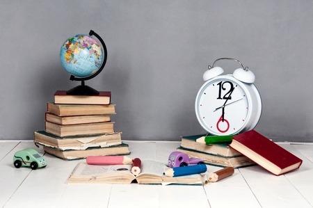 Alarm clock, books, toys and globe on a gray background.の写真素材