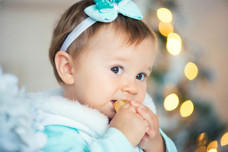 A sweet little girl is eating a chocolate candy. Christmas mood.の写真素材