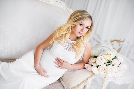 Beautiful pregnant woman in waiting for the baby. Pregnancy. Care, tenderness, maternity, childbirth.の写真素材