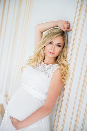 Pregnancy in a white lace dress. Waiting for the baby.の写真素材
