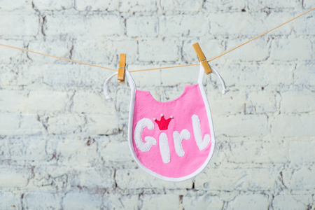 Childrens toddler pink saliva on a rope on a white brick wall background.の写真素材