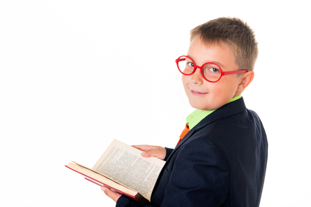 Boy reading a book thirsty for knowledge - isolated over a white background.の写真素材