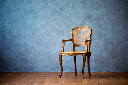 old chair on a gray wall background.の写真素材