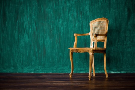 old chair on a green wall backgroundの写真素材