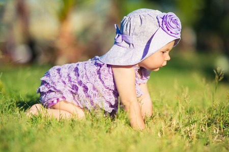 Portrait of a happy girl on vacation. A girl in purple is sitting on the lawn.の写真素材