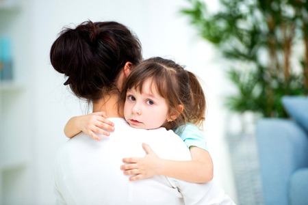 Mom hugs little daughter. Maternal love and family happiness. Happy children and parenthoodの写真素材