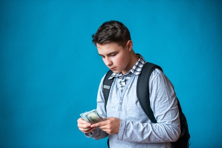 Cash loan, first easy money and spending money. The boy teenager holds in the hands the earned money. Earnings or winnings online.の写真素材