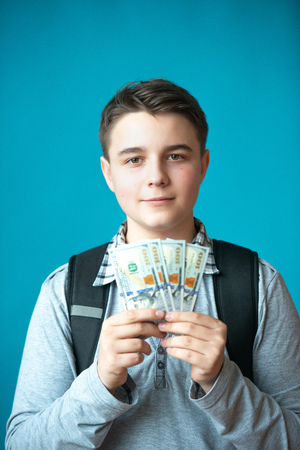 Cash loan, first easy money and spending money. The boy teenager holds in the hands the earned money. Earnings or winnings online.の写真素材