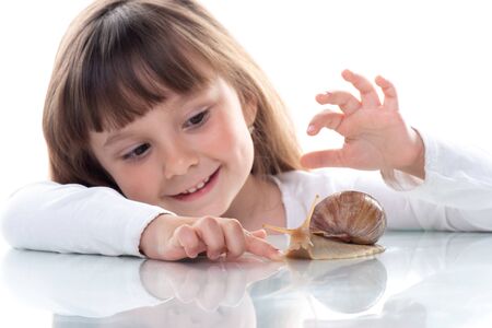 Cute little girl and Akhatina snail. Close up. Concept of youth and beauty skin, facial rejuvenation.の写真素材