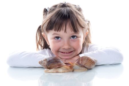 Cute little girl and Akhatina snail. Close up. Concept of youth and beauty skin, facial rejuvenation.の写真素材