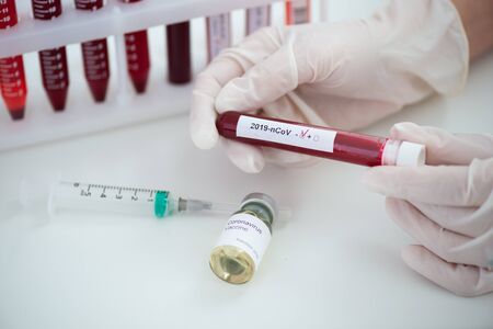 Test tubes with blood sample Covid-19 coronavirus. Vaccine and syringe injection It use for...