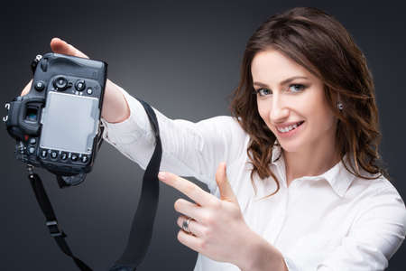Cute girl photographer holding a professional camera in her hands. high quality photo