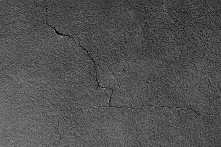 Gray wall with a crack. Texture of rough plaster with uneven granular coating. high quality photo