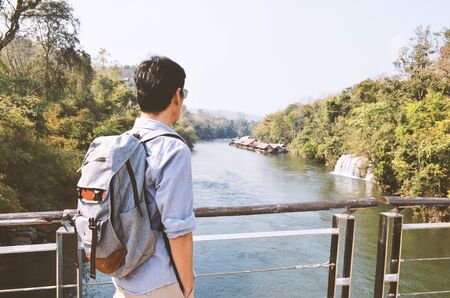 Senior man  with backpack  enjoying view, looking river, relax weekend holiday concept.の写真素材
