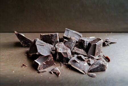 Dark chocolate or Broken chocolate piece on brown background, Top view